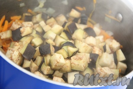 Добавить кусочки баклажана в кастрюлю с овощами и влить воду, хорошо перемешать, дать закипеть, а затем варить на небольшом огне 5 минут.