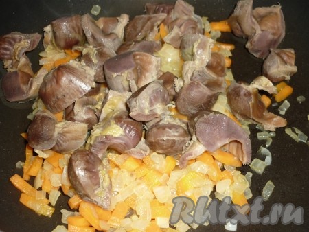 В сковороду с жареными овощами выложить куриные желудочки. 
