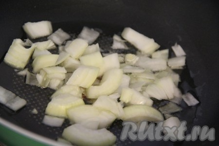 Пока наша курочка готовится в духовке, мы займёмся овощным гарниром. Лук почистить и крупно нарезать, можно - полукольцами, а можно нарезать квадратиками. В сковороду добавить растительное масло и выложить лук. Я готовила овощи в глубокой сковороде. Обжарить лук до прозрачности, периодически помешивать.
