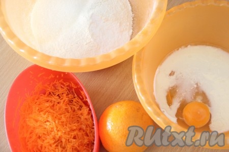 Приступаем к приготовления теста для морковно-апельсиновых кексов. Муку и разрыхлитель просеять в глубокую миску. Добавить сахар. В отдельной миске соединить молоко, яйцо и растительное масло. Морковь почистить и натереть на мелкой тёрке. Апельсин вымыть и обсушить.
