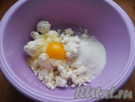 Прежде всего замесим тесто для творожной запеканки, для этого творог выложить в объёмную миску, добавить яйцо и всыпать сахар.