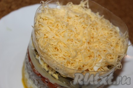 Натереть сыр на мелкой терке и выложить поверх яиц. Накрыть слоеный салат с куриной печенью пищевой пленкой и убрать в холодильник примерно на 30 минут.
