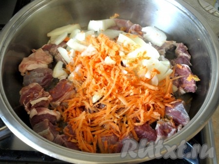 Нарезать говядину небольшими кусочками. Натереть морковь на средней тёрке, а лук нарезать полукольцами. В сковороде разогреть подсолнечное масло, выложить овощи вместе с мясом.
