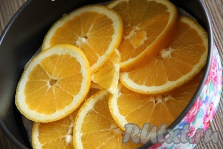 Выложить кружочки апельсина в форму. Апельсиновые дольки выкладывать внахлёст.