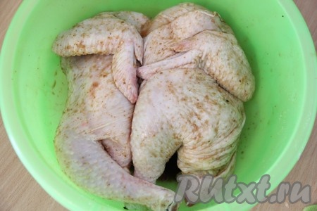 Курицу разрезать пополам, посолить, добавить специи, а затем хорошо втереть специи в мясо. Оставить мариноваться на 2 часа.
