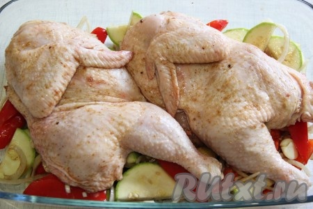 Поверх овощей выложить две части курицы, поставить форму в разогретую духовку и запекать при 220 градусах примерно 45-50 минут.
