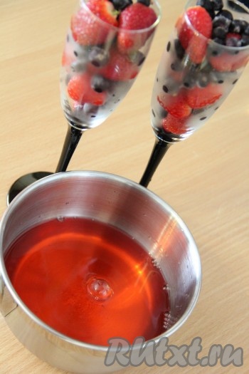 В бокалы (или стаканы) влить желатиновую смесь, заполняя ёмкости до краёв, чтобы ягоды (или фрукты) полностью покрылись желе. 