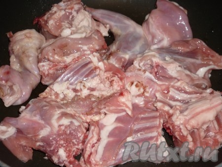 Мясо кролика нарезать на порционные кусочки. В сковороде разогреть растительное масло, выложить кусочки кролика и обжарить на сильном огне с двух сторон до золотистой корочки. 