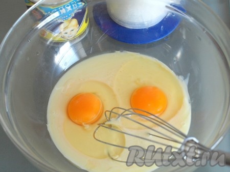 В миску вылить сгущённое молоко, добавить 2 яйца и хорошо перемешать.
