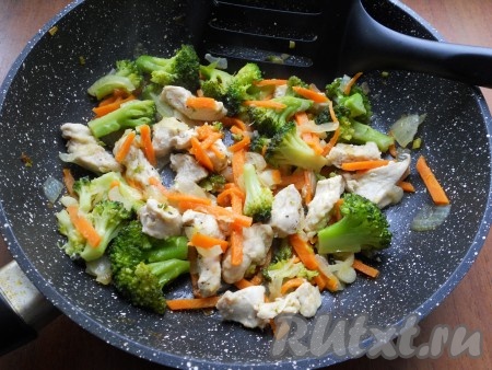 Сковороду накрыть крышкой и тушить куриное филе с брокколи, морковкой и луком на маленьком огне 10-15 минут, периодически перемешивая.
