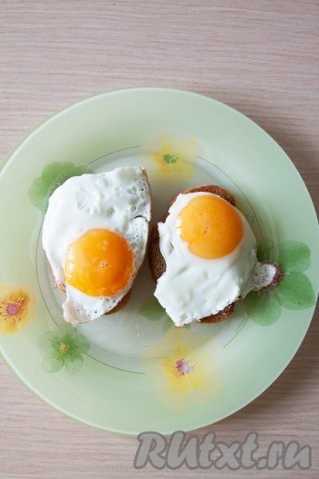 На той же сковороде обжарьте яйца, как вам больше нравится (с жидким желтком или плотным). При приготовлении посыпьте солью. Уложите готовую яичницу на тост.
