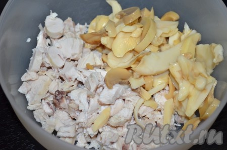 Добавить нарезанные маринованные шампиньоны к курице.
