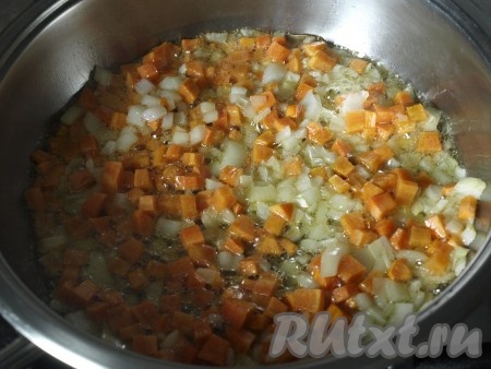 Разогреть в сковороде растительное масло, выложить лук с морковью и слегка обжарить, не забывая иногда перемешивать.

