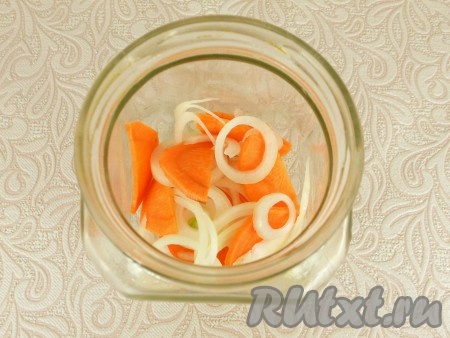 На следующий день можно будет продолжать процесс приготовления сельди по-голландски. Для этого нужно очистить лук и нарезать его на тонкие колечки (или полукружочки). Очищенную морковку нужно будет нарезать на тонкие полукружочки. В подходящую по объёму банку выложить 1/4 часть нарезанных лука и моркови.