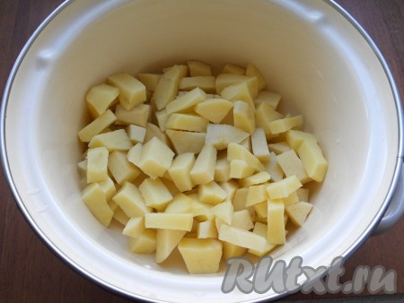 Картофель очистить и нарезать небольшими кубиками в кастрюлю.
