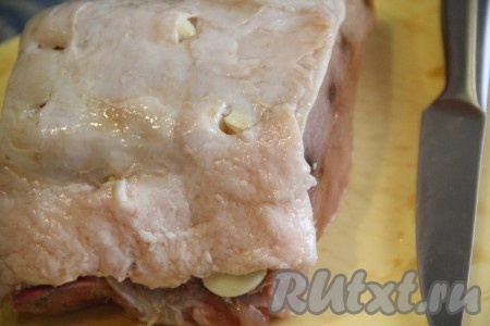 С помощью острого ножа сделать надрезы на поверхности мяса и вставить пластинки чеснока.