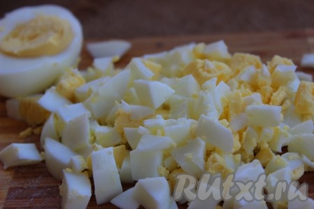 Яйца отварить вкрутую, охладить, очистить и нарезать на кубики среднего размера.
