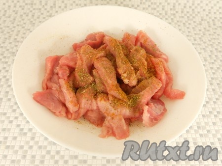 Свинину посыпать специями для мяса, добавить немного хмели-сунели, перемешать.
