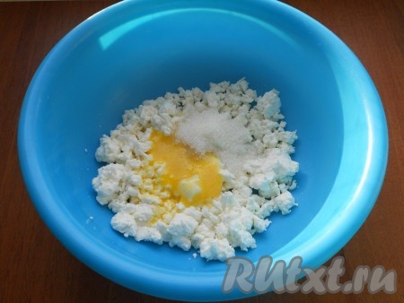 Яйцо разделить на белок и желток. Творог выложить в миску, добавить желток, всыпать ванилин и сахар.
