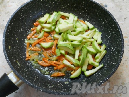 К моркови добавить лук, обжаривать овощи 2-3 минуты. Добавить в сковороду кабачки, посолить, перемешать.
