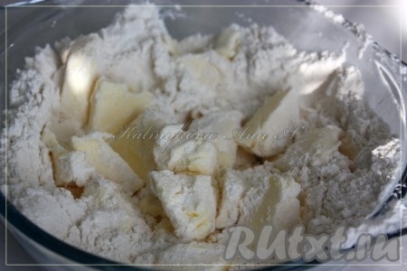 Для приготовления основы для пирога сливочное масло нужно порубить на кусочки, добавить его в муку, положить соль и перемешать.