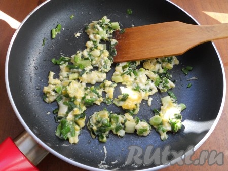Далее добавить в сковороду сырое яйцо и быстро его перемешать с зеленью.